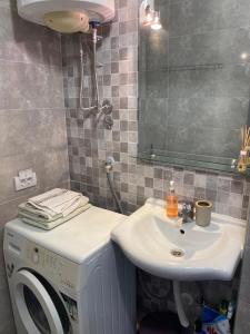 a bathroom with a sink and a washing machine at Sun Apartment in Tivat +2 photos