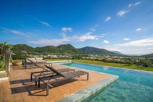 a swimming pool with benches and a view of a city at Cozy Studios in Floripa - OKA in Florianópolis
