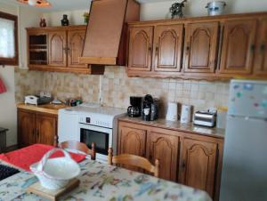 a kitchen with wooden cabinets and a white stove top oven at Maison 'Dédé' in La Chapelle-Taillefert