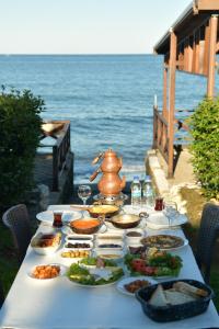 a table with food on it next to the ocean at Pasha Tatil Köyü in Akcaabat