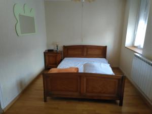 a bedroom with a wooden bed in a room at Maison 'Dédé' in La Chapelle-Taillefert
