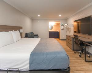 a hotel room with a large bed and a desk at Economy Suites Springfield - Extended Stay in Springfield +3 photos