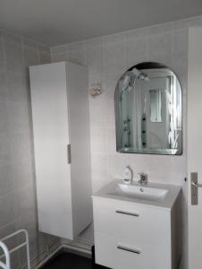 a bathroom with a white sink and a mirror at Maison 'Dédé' in La Chapelle-Taillefert