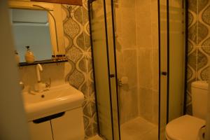 a bathroom with a shower and a sink and a toilet at Pasha Tatil Köyü in Akcaabat