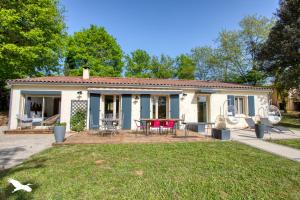 a small white house with a table and chairs at Le Nid du Coderc in Carsac-Aillac