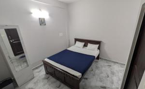 a small bedroom with a bed and a mirror at Mrinal Homestay in Ponda
