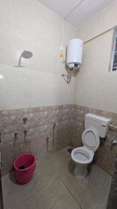 a bathroom with a toilet and a bucket in it at Mrinal Homestay in Ponda