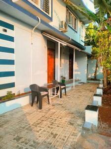 a patio of a house with a table and benches at Mrinal Homestay in Ponda