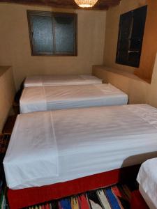 a room with three beds in a room at Auberge amazrane in Matat