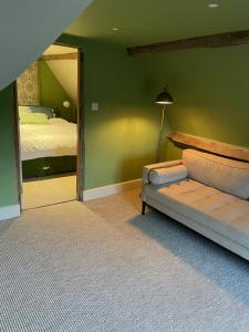 a bedroom with a bed and a couch and a mirror at Swan Farm in Daventry