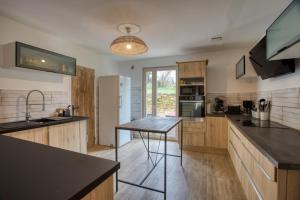 a kitchen with wooden cabinets and a counter top at Le Nid du Coderc in Carsac-Aillac