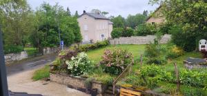a garden with flowers in front of a house at Chambre calme Aux Iris in Grandvelle-et-Perrenot