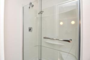 a glass shower door with a silver handle at Chateau Riverside in Campbell River +43 photos