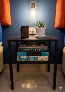 a table with books and a potted plant on it at Isaiah CityScape in Manila