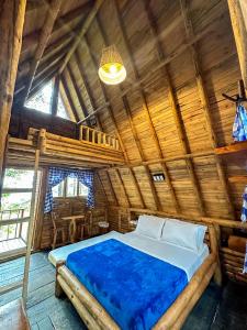 a bedroom with a bed in a wooden room at Los Pinos EcoHotel in Hobo