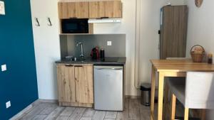 a small kitchen with a sink and a refrigerator at Studio Provence in Istres