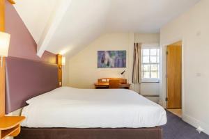 a bedroom with a white bed and a window at ALTY Hotel in Broadheath