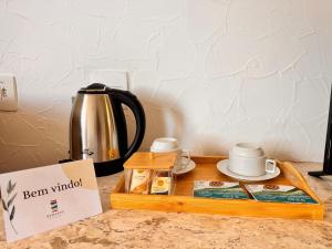a tea kettle and cups on a wooden tray at Villa Nautilus Be Happy in Fortaleza