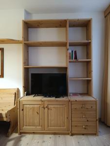 a large wooden entertainment center with a flat screen tv at Appartamento Marmolada in Pieve di Livinallongo