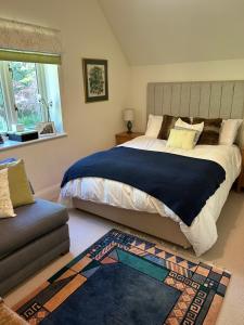 a bedroom with a large bed and a couch at Bourne House in Mursley