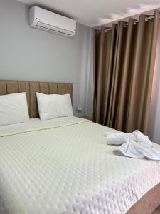 a bed with two towels sitting on top of it at David's House in Ndërlysaj