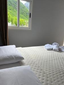 a bed with towels on it in a room with a window at David's House in Ndërlysaj +12 photos