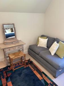 a living room with a couch and a mirror at Bourne House in Mursley