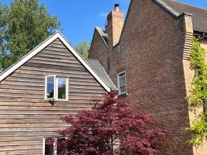 a house with a red tree in front of it at Bourne House in Mursley +17 photos