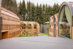 a backyard with a wooden fence and a driveway at Feinheit Hotel & Restaurant, Tor zu Hunsrück und Mittelrhein! Mit Sauna Hot Tub und Gartensuite in Halsenbach