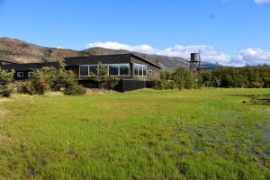 a house in the middle of a field at Geikie Lodge in Torres del Paine