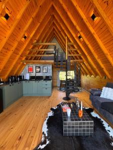 a living room with a couch and a kitchen in a barn at Chalé Recanto da Ema in Urubici