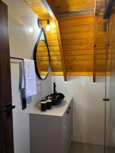 a bathroom with a sink and a mirror at Chalé Recanto da Ema in Urubici