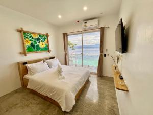 a bedroom with a bed with a view of the ocean at Antuwanga reef resort in Moalboal +51 photos