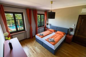 a bedroom with a bed with orange sheets and windows at Casa-Friuli Doppelhaus Villa in Gradisca dʼIsonzo +61 photos