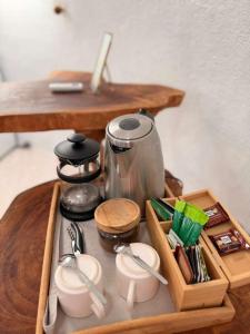 a table with a tray with utensils and a tea kettle at Suites Al Mar, en el malecón de San Cristóbal in San Cristóbal
