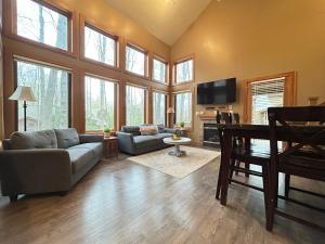 a living room with a couch and a tv at Ski-In 5BR Retreat at Boyne Mtn - Walk to Lifts & Fun! in Boyne Falls