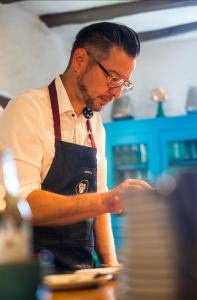 a man in a kitchen preparing food at B&B Echternacher Hof in Kinheim
