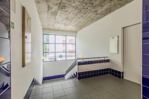 a bathroom with blue and white tiles and a window at HI Beja - Pousada de Juventude in Beja +28 photos