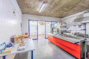 a kitchen with a rediciasteryasteryasteryasteryasteryasteryasteryasteryasteryastery at HI Beja - Pousada de Juventude in Beja