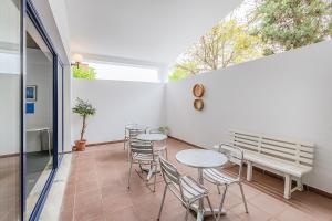 a balcony with tables and chairs and a window at HI Beja - Pousada de Juventude in Beja