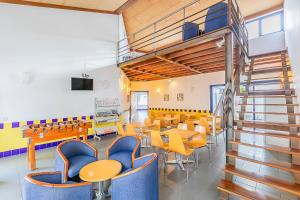 a classroom with tables and chairs and a staircase at HI Beja - Pousada de Juventude in Beja