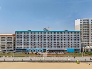 a large building on the beach next to the beach at The Barclay Towers Hotel and Resort in Virginia Beach