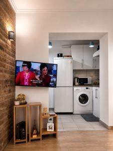 a kitchen with a flat screen tv on a wall at OM Center Apartments Tirana in Tirana