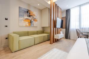 a hotel room with a couch and a tv at Numa Apart-Hotel in Tirana
