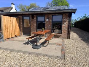 a tiny house with a picnic table and a solar roof at B&B Goeje Morge in Ammerzoden