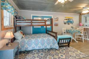 a bedroom with two bunk beds and a table at 1 Mi to Ocean Isle Beach! Studio w/ Outdoor Oasis in Ocean Isle Beach