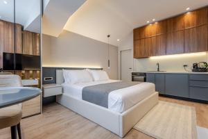 a bedroom with a large white bed and a kitchen at Numa Apart-Hotel in Tirana