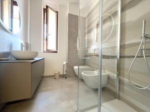 a bathroom with a sink and a toilet and a shower at Lake and Rocca Suite in Angera +12 photos