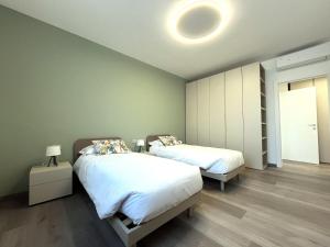 a bedroom with two beds and a light on the ceiling at Lake and Rocca Suite in Angera