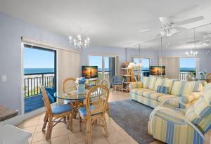 a living room with a couch and a table and chairs at Gulf Strand Resort by Travel Resort Services in St. Pete Beach